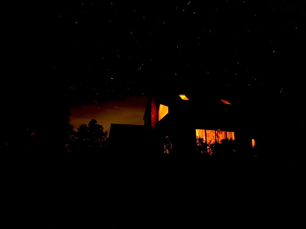 lit house against dark starry sky